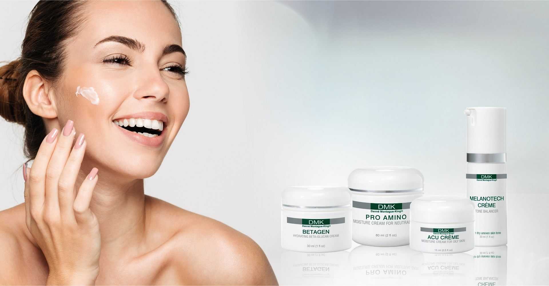 Woman applying skincare with DMK products displayed.